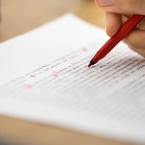 une personne en train d'annoter un synopsis avec un stylo rouge