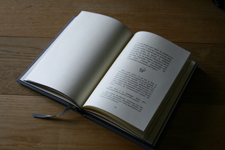 livre ouvert en belle page un texte séparé par un couillard en forme de tête de mort