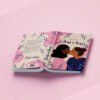 Mockups Design le livre ouvert laissant visible 4e de couverture, dos et première de couverture flat design une jeune femme à la peau foncée et aux cheveux noir embrasse une femme blanche aux cheveux châtains coiffés en chignon. Le fond est rose et beige avec des petites feuilles bleues.